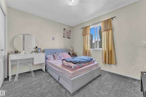Carpeted bedroom featuring baseboards and a textured ceiling - 6152 13 Avenue, Edmonton, AB - Indoor Photo Showing Bedroom
