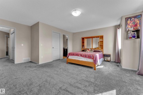 Carpeted bedroom with baseboards and a textured ceiling - 6152 13 Avenue, Edmonton, AB - Indoor Photo Showing Bedroom