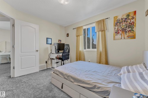 Carpeted bedroom with a desk and a textured ceiling - 6152 13 Avenue, Edmonton, AB - Indoor Photo Showing Bedroom
