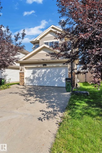 View of front facade featuring stone siding, driveway, and a garage - 6152 13 Avenue, Edmonton, AB - Outdoor