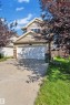 View of front facade featuring stone siding, driveway, and a garage - 6152 13 Avenue, Edmonton, AB  - Outdoor 
