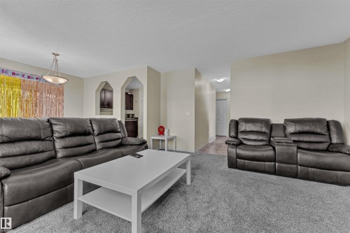 Living area featuring light colored carpet and a textured ceiling - 6152 13 Avenue, Edmonton, AB - Indoor Photo Showing Living Room