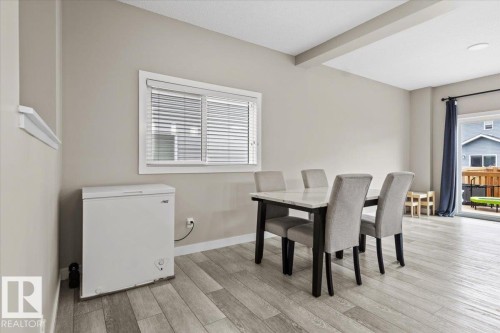 Open concept living area featuring light wood-finish flooring, a contemporary window with blinds, and a sliding glass door leading to an outdoor space - 236 39 Avenue, Edmonton, AB - Indoor Photo Showing Dining Room