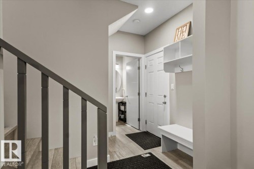 Entryway featuring wood-finish flooring, a white built-in storage bench, and an overhead storage shelf - 236 39 Avenue, Edmonton, AB - Indoor Photo Showing Other Room