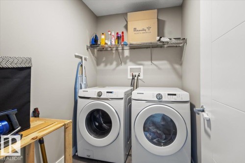 Dedicated laundry area featuring a front-loading washer and dryer, wall-mounted wire shelving, and neutral wall paint - 236 39 Avenue, Edmonton, AB - Indoor Photo Showing Laundry Room