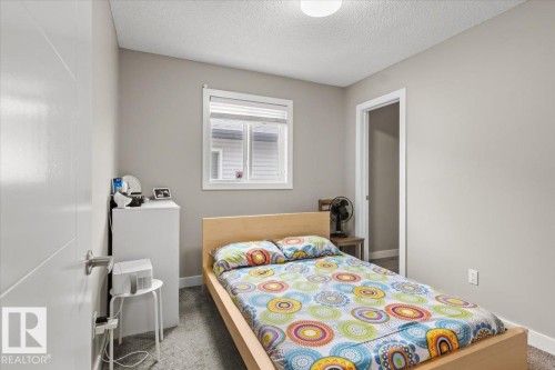 Carpeted room featuring a window with white blinds, a white flush-mount ceiling light, and a white interior door - 236 39 Avenue, Edmonton, AB - Indoor Photo Showing Bedroom