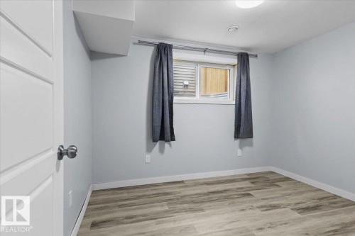 Room featuring wood-finish flooring, a white trim baseboard, and light gray painted walls - 236 39 Avenue, Edmonton, AB - Indoor Photo Showing Other Room