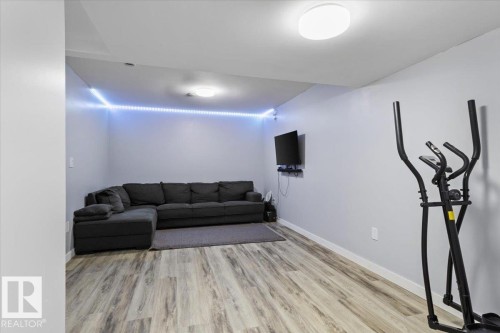 Spacious room featuring wood-finish flooring, light grey walls, and a recessed ceiling light - 236 39 Avenue, Edmonton, AB - Indoor