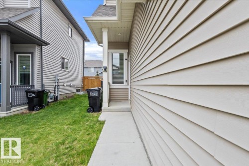 Property exterior featuring horizontal siding, a concrete pathway, and a side entrance with a transom window - 236 39 Avenue, Edmonton, AB - Outdoor