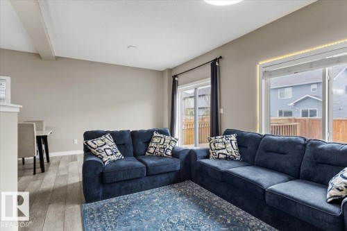 Open-concept living area featuring wood-finish flooring, recessed lighting, and expansive sliding glass doors - 236 39 Avenue, Edmonton, AB - Indoor Photo Showing Living Room