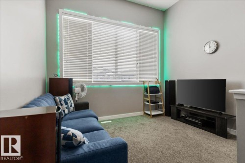 Carpeted room featuring a large window with blinds, light gray wall paint, and integrated ambient lighting - 236 39 Avenue, Edmonton, AB - Indoor