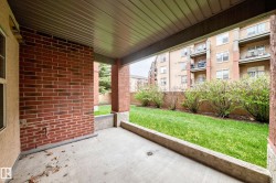 Covered patio featuring a concrete slab floor, brick wall, and soffit ceiling - 