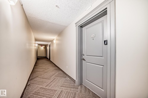 Entry door with light gray paint finish and contrasting trim - 113 11441 Ellerslie Road, Edmonton, AB - Indoor Photo Showing Other Room