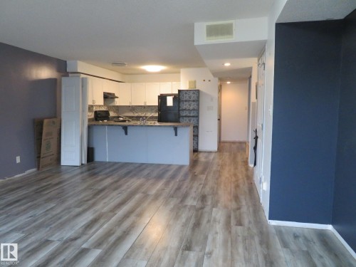 Open-concept kitchen and living area featuring wood-finish flooring, white cabinetry, and recessed lighting - 2945 26 Street, Edmonton, AB - Indoor Photo Showing Kitchen