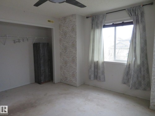 Room featuring a ceiling fan with light fixture, window with curtains, and an open closet with built-in shelving - 2945 26 Street, Edmonton, AB - Indoor
