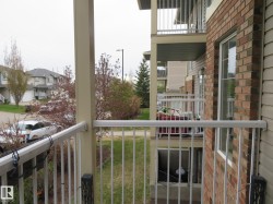Private balcony featuring white metal railings and a beige support pillar - 
