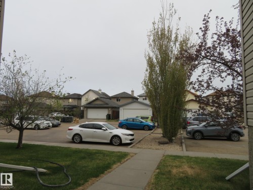 Front yard with a concrete walkway, green lawn, and mature trees - 2945 26 Street, Edmonton, AB - Outdoor
