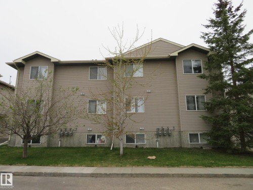 Multi-story building featuring tan horizontal siding and multiple double-pane windows - 2945 26 Street, Edmonton, AB - Outdoor