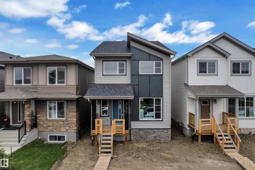 Modern two-story residence featuring a distinctive facade with light gray siding and dark gray vertical panels - 17330 6A Street Ne, Edmonton, AB - Outdoor With Facade