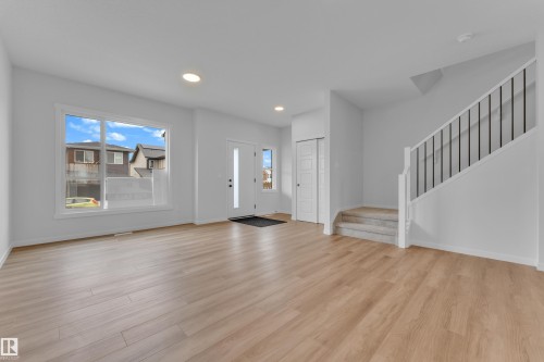 Open-concept living area featuring wood-finish flooring, recessed lighting, and a white interior color palette - 17330 6A Street Ne, Edmonton, AB - Indoor Photo Showing Other Room