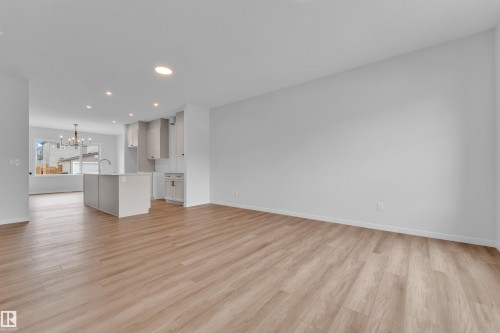 Open-concept living area featuring wood-finish flooring, recessed lighting, and a neutral color palette - 17330 6A Street Ne, Edmonton, AB - Indoor