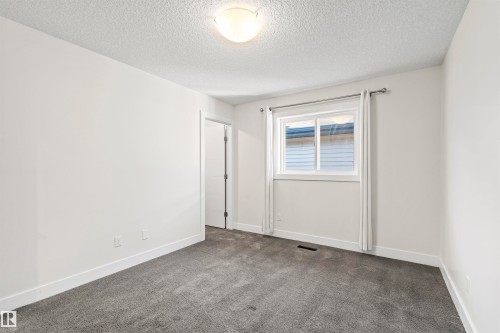 Carpeted room featuring a double-paned window, white trim, and a flush mount ceiling light - 2036 Ainslie Link Link, Edmonton, AB - Indoor Photo Showing Other Room