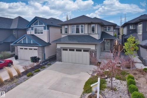 Contemporary exterior with multi-toned siding, dark gray roof, and stone accents - 2036 Ainslie Link Link, Edmonton, AB - Outdoor With Facade