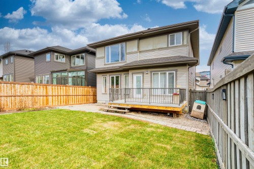 Expansive backyard featuring a manicured lawn and a wooden privacy fence - 2036 Ainslie Link Link, Edmonton, AB - Outdoor With Deck Patio Veranda