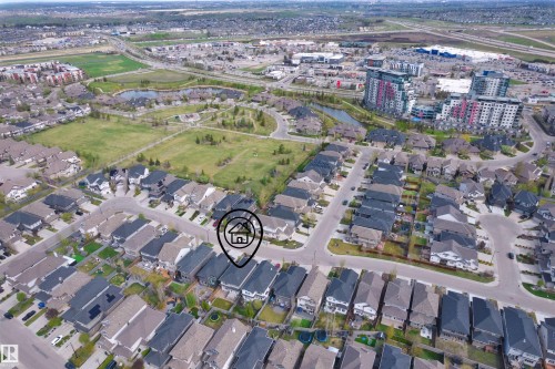 Residential area featuring mature landscaping, a pond, and multiple multi-story apartment buildings - 2036 Ainslie Link Link, Edmonton, AB - Outdoor With View