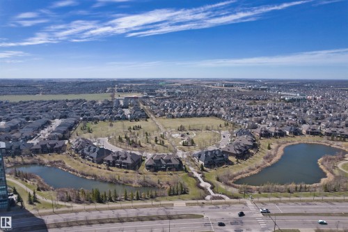 Aerial perspective showcasing a residential community with two distinct ponds, surrounding green spaces, and connecting pathways - 2036 Ainslie Link Link, Edmonton, AB - Outdoor With View