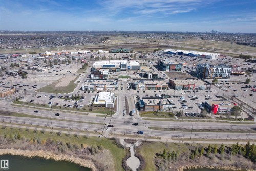 Aerial perspective of a commercial district featuring multiple retail and office buildings, extensive paved parking areas, and multi-lane roadways - 2036 Ainslie Link Link, Edmonton, AB - Outdoor With View