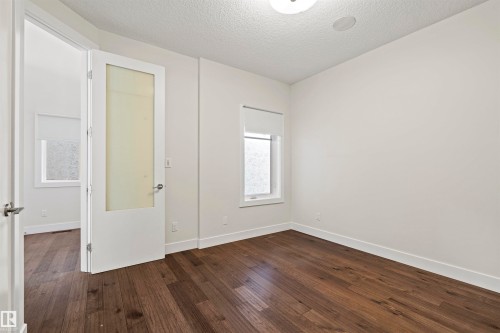 Room featuring wood-finish flooring, white baseboards, and neutral wall tones - 2036 Ainslie Link Link, Edmonton, AB - Indoor Photo Showing Other Room