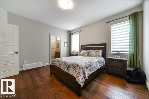 Bedroom featuring dark wood-finish flooring and light gray walls - 3 8050 Orchards Green, Edmonton, AB - Indoor Photo Showing Bedroom
