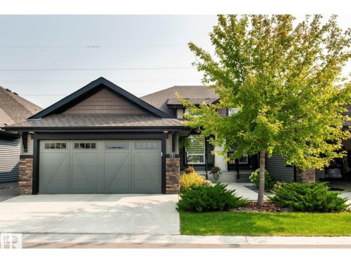Contemporary exterior featuring a gabled roofline, stone accents, and shake siding - 3 8050 Orchards Green, Edmonton, AB - Outdoor