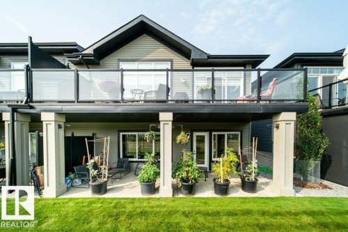 Rear exterior featuring multi-level outdoor living spaces - 3 8050 Orchards Green, Edmonton, AB - Outdoor With Deck Patio Veranda