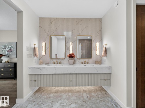 Floating double vanity with a veined countertop, integrated sinks, and fluted cabinet fronts - 7104 54 Avenue, Beaumont, AB - Indoor Photo Showing Bathroom