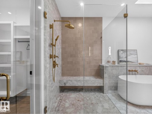 Spacious walk-in shower with a built-in bench, full glass enclosure, and a freestanding soaking tub - 7104 54 Avenue, Beaumont, AB - Indoor Photo Showing Bathroom