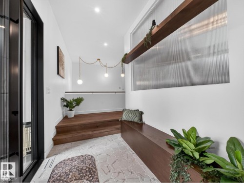 Entryway featuring decorative tile flooring, a built-in wood-finish bench, and recessed lighting - 7104 54 Avenue, Beaumont, AB - Indoor Photo Showing Other Room
