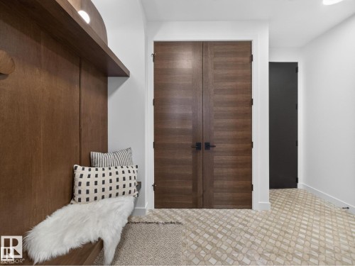 Entryway featuring a built-in wood bench with integrated shelving, recessed lighting, and a wood-finish wall panel - 7104 54 Avenue, Beaumont, AB - Indoor