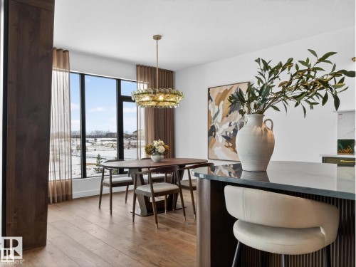 Dining area featuring large-format windows, wood-finish flooring, and a decorative chandelier - 7104 54 Avenue, Beaumont, AB - Indoor Photo Showing Dining Room