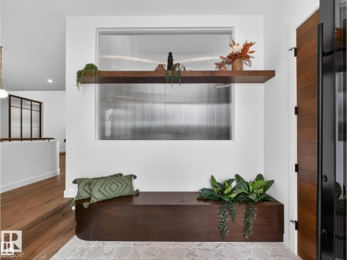 Integrated wood-finish bench seating with a coordinating floating shelf - 7104 54 Avenue, Beaumont, AB - Indoor Photo Showing Other Room
