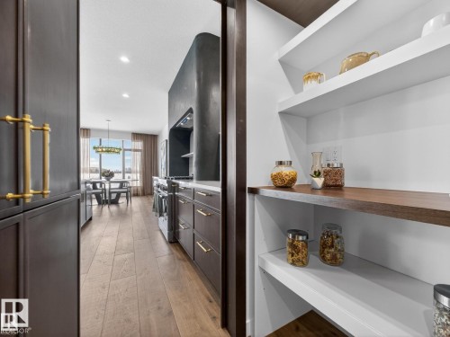 Built-in pantry featuring white shelving and a wood-finish counter - 7104 54 Avenue, Beaumont, AB - Indoor