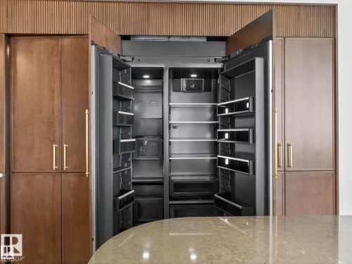 Integrated dual-door refrigerator with dark interior and stainless steel shelving - 7104 54 Avenue, Beaumont, AB - Indoor Photo Showing Kitchen