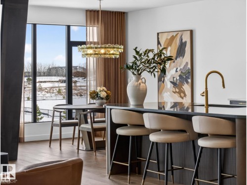 Contemporary kitchen island with a dark countertop and fluted paneling - 7104 54 Avenue, Beaumont, AB - Indoor Photo Showing Dining Room