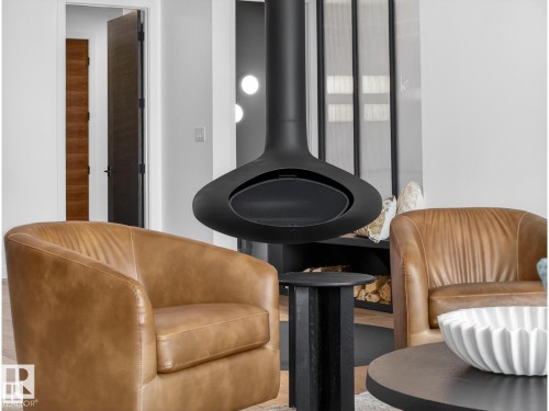 Suspended black fireplace, dark wood-finish interior doors, and a wood storage niche - 7104 54 Avenue, Beaumont, AB - Indoor