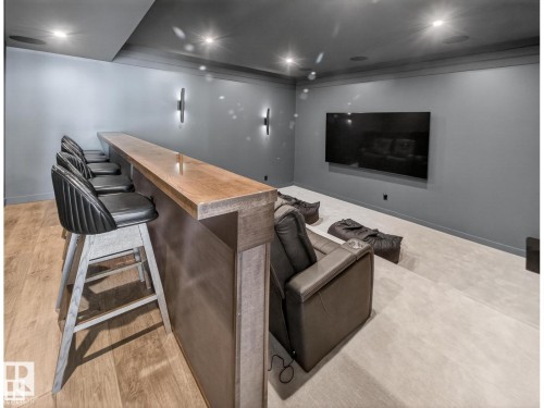 Entertainment space featuring a wood-finish bar, wall-mounted television, recessed lighting, and integrated ceiling speakers - 7104 54 Avenue, Beaumont, AB - Indoor