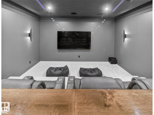 Dedicated media room featuring a tiered layout, overhead recessed lighting, and wall-mounted sconces - 7104 54 Avenue, Beaumont, AB - Indoor