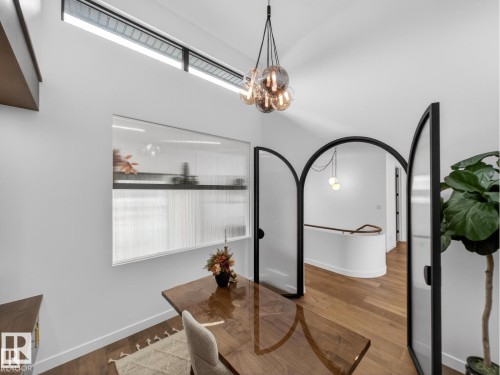 Vaulted ceiling featuring a linear transom window and a cluster pendant light fixture - 7104 54 Avenue, Beaumont, AB - Indoor Photo Showing Other Room