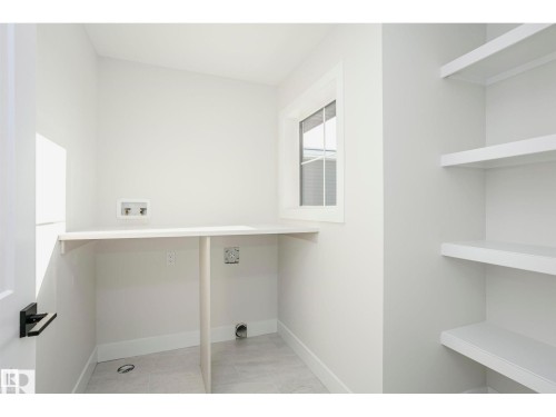 Bright utility space featuring a built-in countertop, window, and integrated shelving - 6302 Dansereau Crescent, Beaumont, AB - Indoor