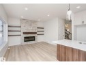 Living area featuring a stone accent wall with a built-in electric fireplace and integrated wood-finish shelving - 6302 Dansereau Crescent, Beaumont, AB  - Indoor With Fireplace 